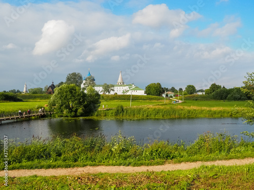 photo of the wide Suzdal river near Russian white stone Orthodox churches