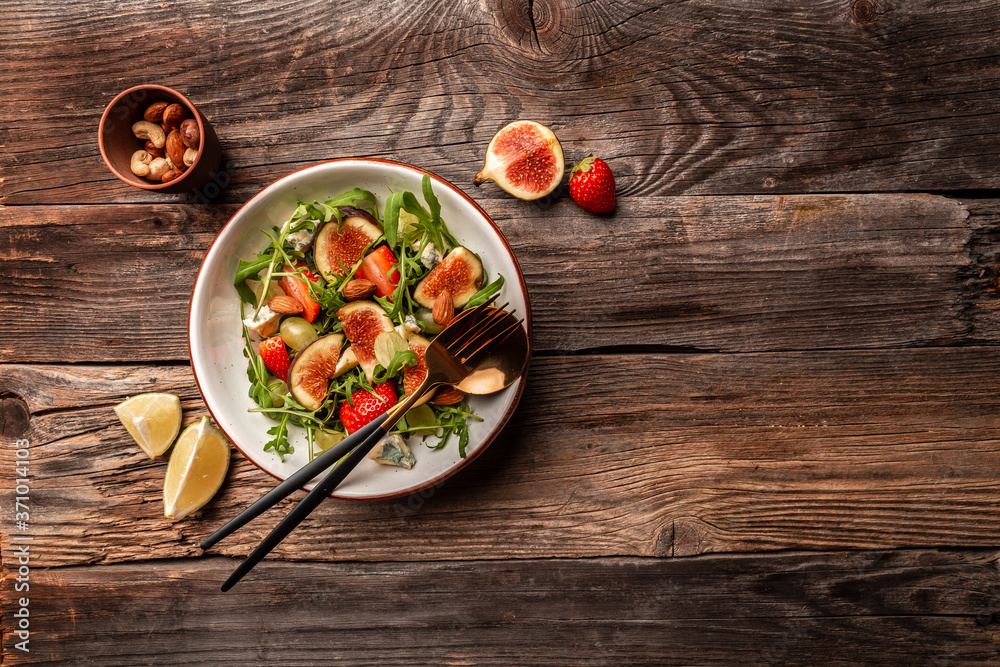 Diet menu. Healthy salad of fresh vegetables Fig, arugula, strawberries, grapes, blue cheese salad, Flat lay. Banner. Top view