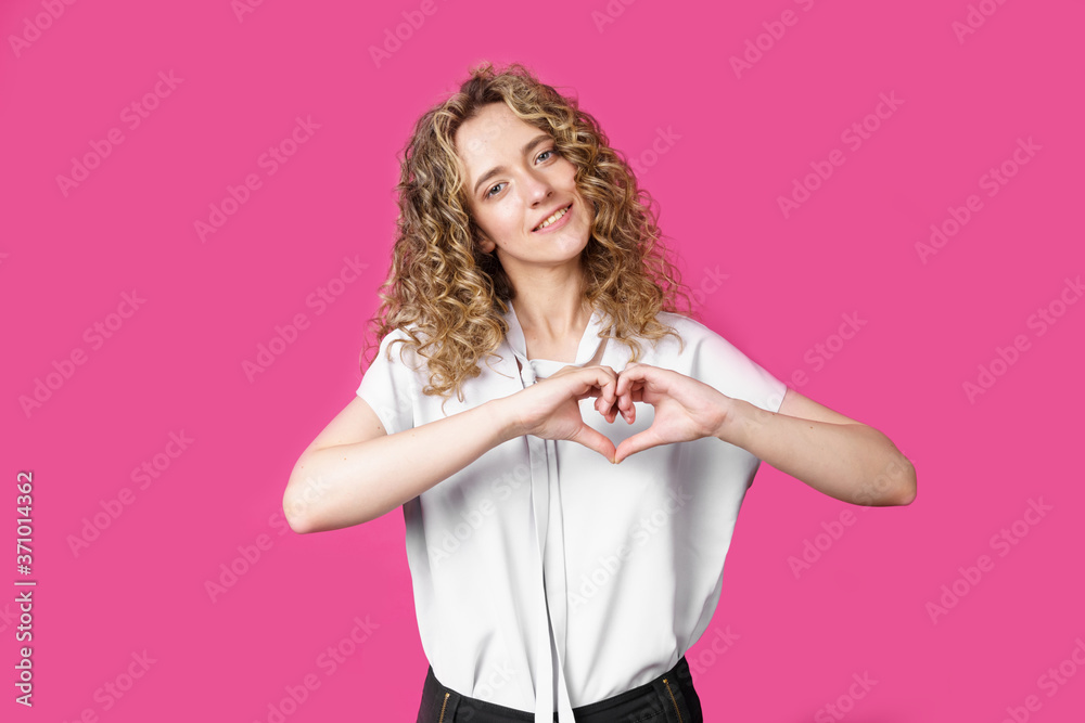 Portrait of a beautiful woman who shows a heart gesture on her chest, passionately, expresses love for a loved one. Portrait of a beautiful woman who shows a heart gesture on her chest, passionately, expresses love for a loved one.
