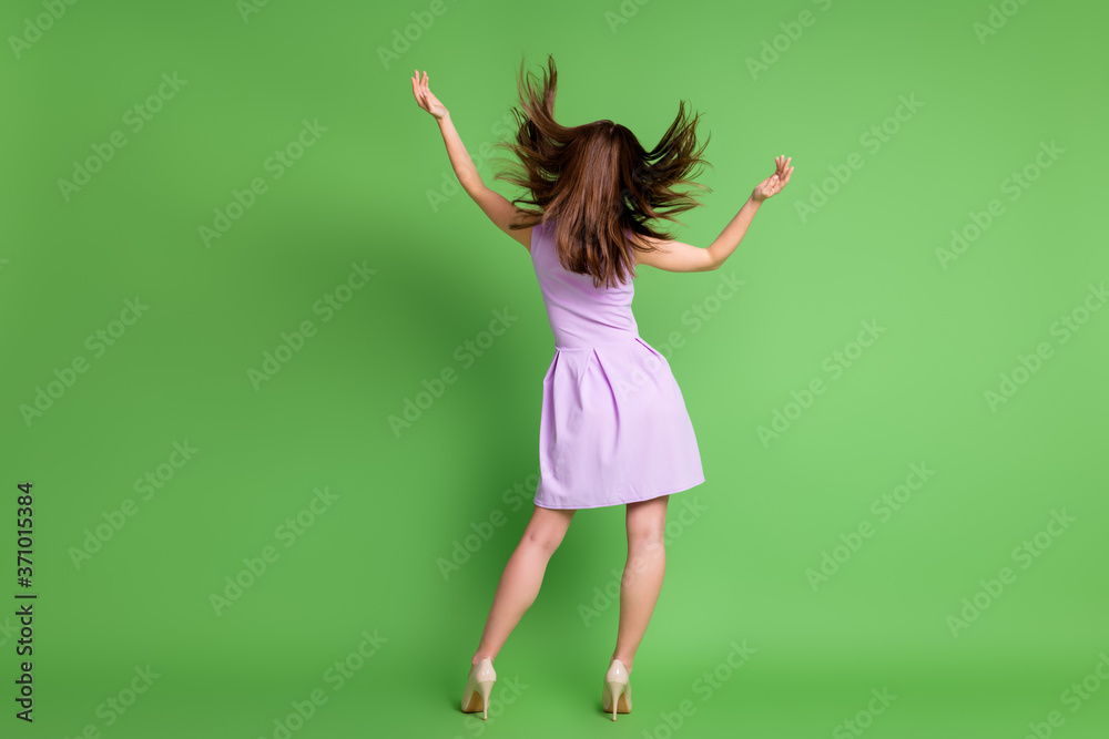 Full length rear behind view photo of pretty tall slender lady turned back throw hairdo flight blow enjoy warm spring season breeze wear mini dress stilettos isolated green color background Full length rear behind view photo of pretty tall slender lady turned back throw hairdo flight blow enjoy warm spring season breeze wear mini dress stilettos isolated green color background