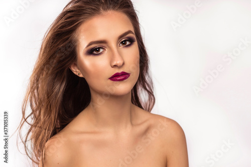 Amazing young woman with wavy hair  bright eyes and red lips. Perfect skin and beautyful hair