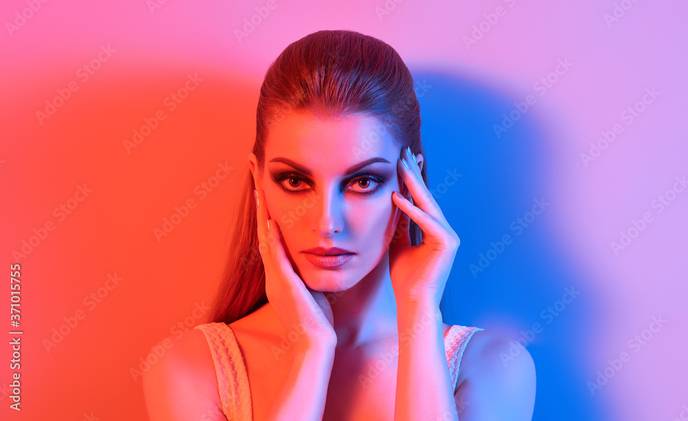 Fototapeta premium Fashion. Woman in colorful neon light, make-up. Beautiful sexy girl, stylish hair, trendy makeup. Party disco neon style. Creative art beauty portrait, fashionable model face, make up