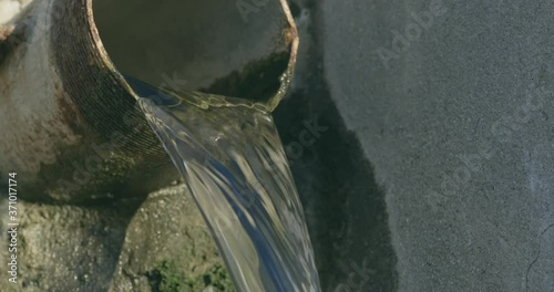  Drainage pipe: Water flows out of a drainage pipe sending a shimmer across the rocks.