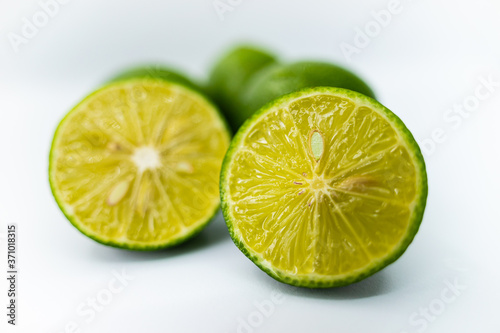 whole and half with slice of fresh green lime isolated on white background. Fresh and real tropical fruit.