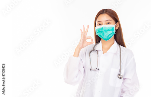 Young female asian doctor with stethoscope in medical mask show okay sign. Confident woman doctor work in clinic or hospital with coronavirus patient  in medical mask. health care  insurance concept