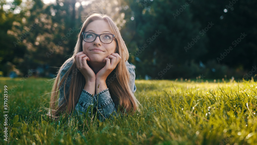 Young caucasian brunette daydreaming while laying on the grass in the park. Relaxation in nature . High quality photo Young caucasian brunette daydreaming while laying on the grass in the park. Relaxation in nature . High quality photo