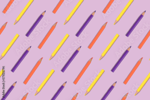 Color pencils pattern on a purple pastel background. Back to school layout.