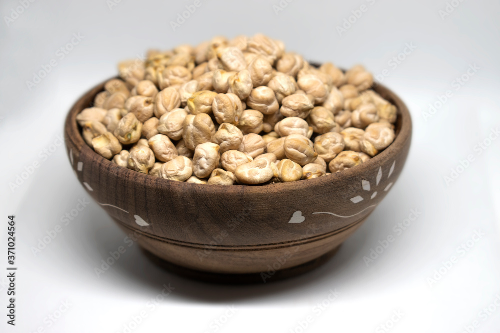 White Chick Pea or Kabuli Chana isolated in wooden bowl on White Background White Chick Pea or Kabuli Chana isolated in wooden bowl on White Background