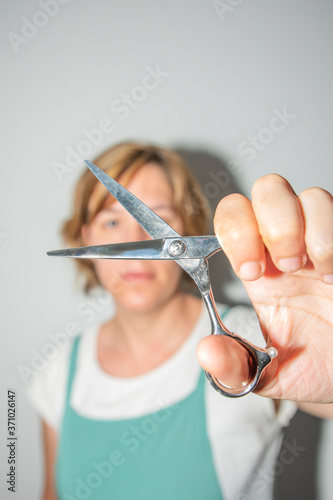 YOUNG CAUCASIAN GIRL WITH SCISSORS AND BARBER BLADE
