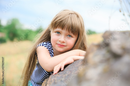 Portrait of a little girl holding hands on a stone