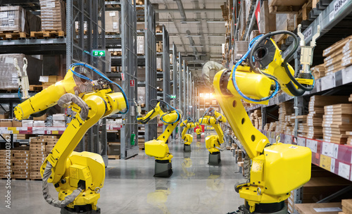 Automatic robot mechanical arm is working in temporary storage in a distribution warehouse.