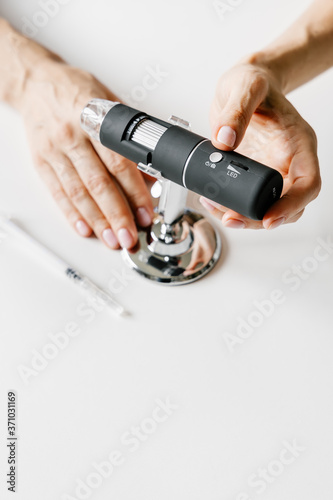 Skin microscope in woman's hands. Modern cosmetology. 