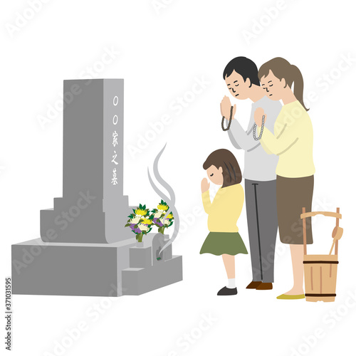 お墓参りをする家族