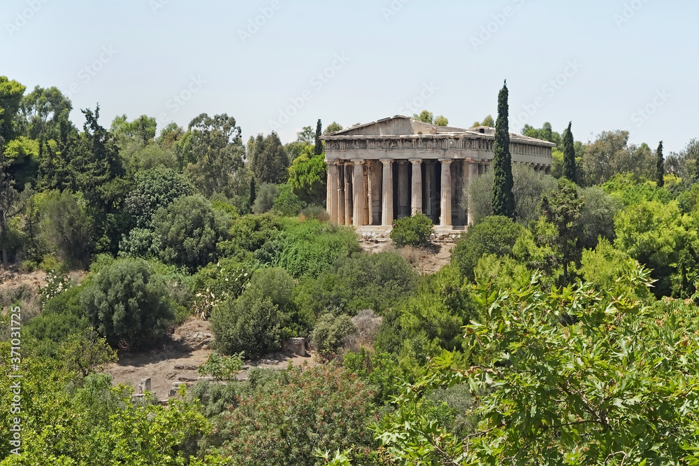 View to the Temple of Hephaestus on top of the Agoraios Kolonos hill covered in greenery in Athens, Greece