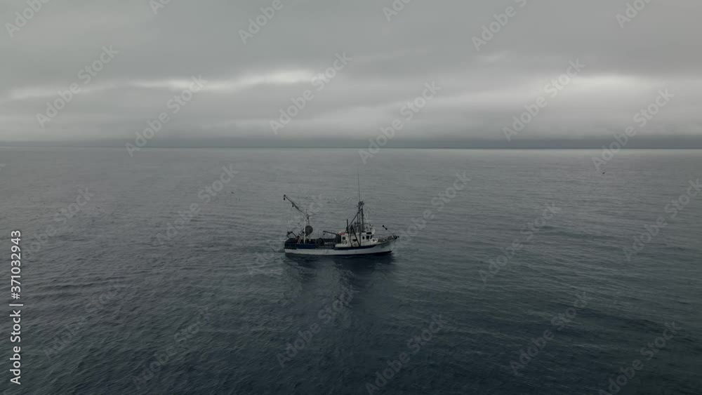 Fishing Trawler Sailing Under The Overcast At The saint Lawrence Gulf In Quebec, Canada. - aerial drone Fishing Trawler Sailing Under The Overcast At The saint Lawrence Gulf In Quebec, Canada. - aerial drone