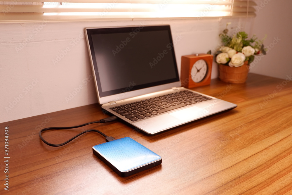Portable external hard drive USB3.0 connect to laptop computer on desk, Data transfer or backup personal files concept Portable external hard drive USB3.0 connect to laptop computer on desk, Data transfer or backup personal files concept