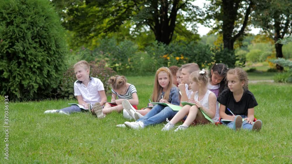 Group of cheerful children learning outdoors at school after quarantine lockdown Group of cheerful children learning outdoors at school after quarantine lockdown