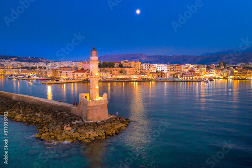 Panorama of the beautiful old harbor of Chania with the amazing lighthouse  mosque  venetian shipyards  at sunset  Crete  Greece.