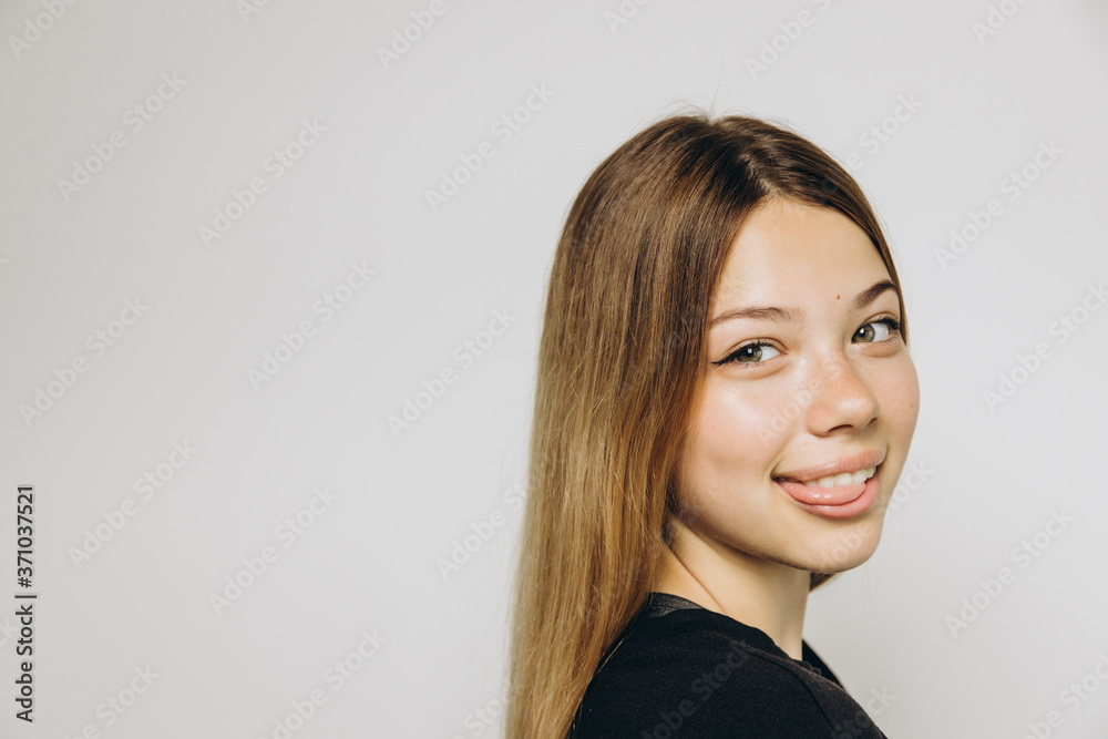 A teenage girl against grey background with copy space A teenage girl against grey background with copy space