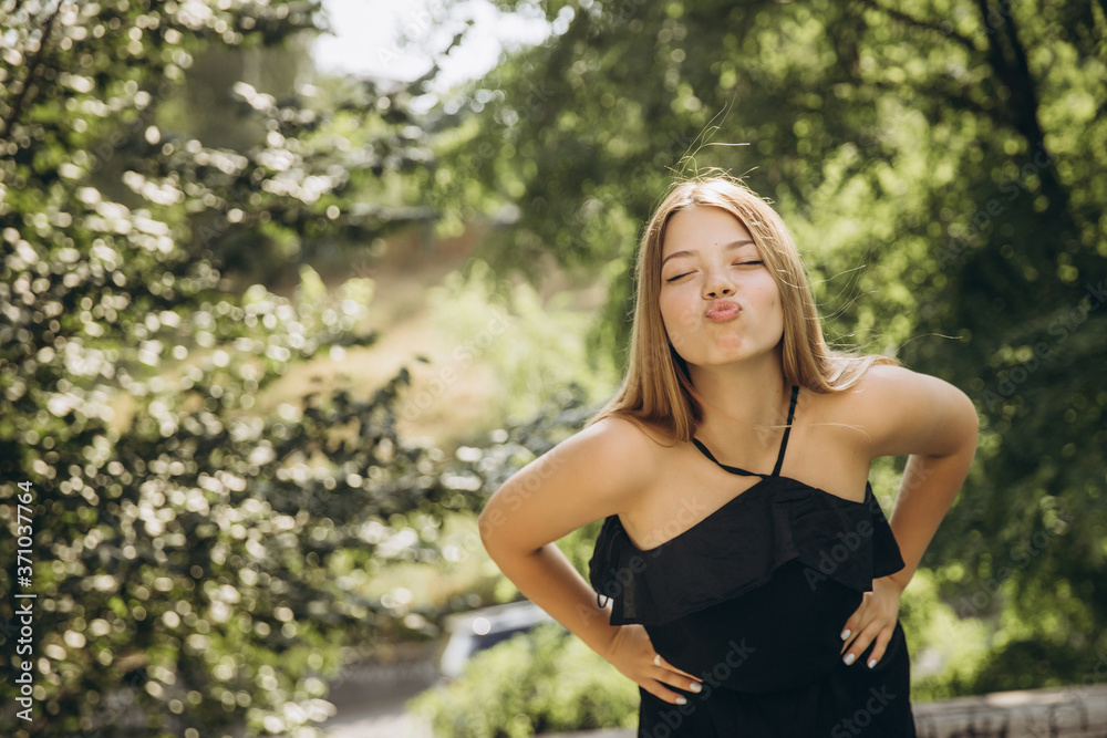 A teenage girl is having a walk in a green city park A teenage girl is having a walk in a green city park