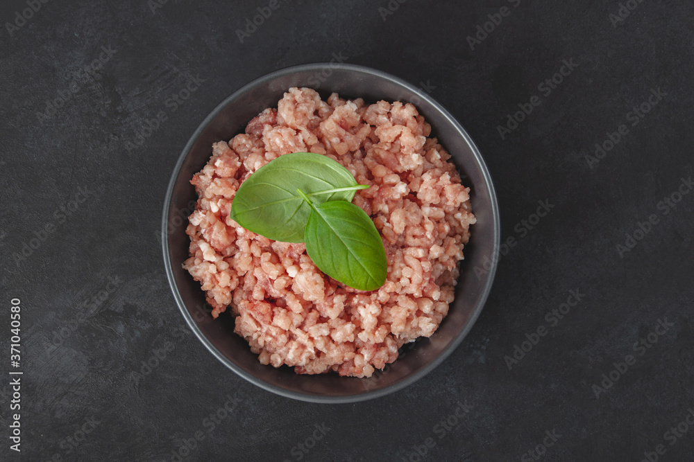 Raw minced meat in bowl on wooden table Raw minced meat in bowl on wooden table
