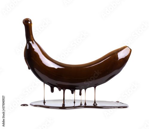 Banana is poured with liquid chocolate on a white background