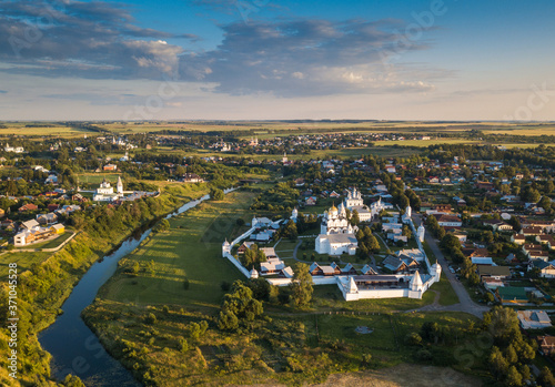 Panoramic aerial view of ancient city Suzdal and Intercession Pokrovsky Monastery in sunset.The Golden Ring of Russia. Vladimir region. Aerial drone photo.