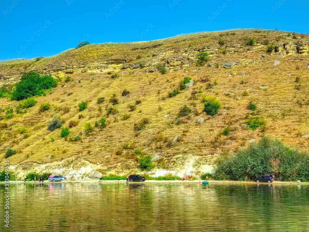 landscape with Dniester river smooth water surface and hill land horizon background in clear summer weather time landscape with Dniester river smooth water surface and hill land horizon background in clear summer weather time