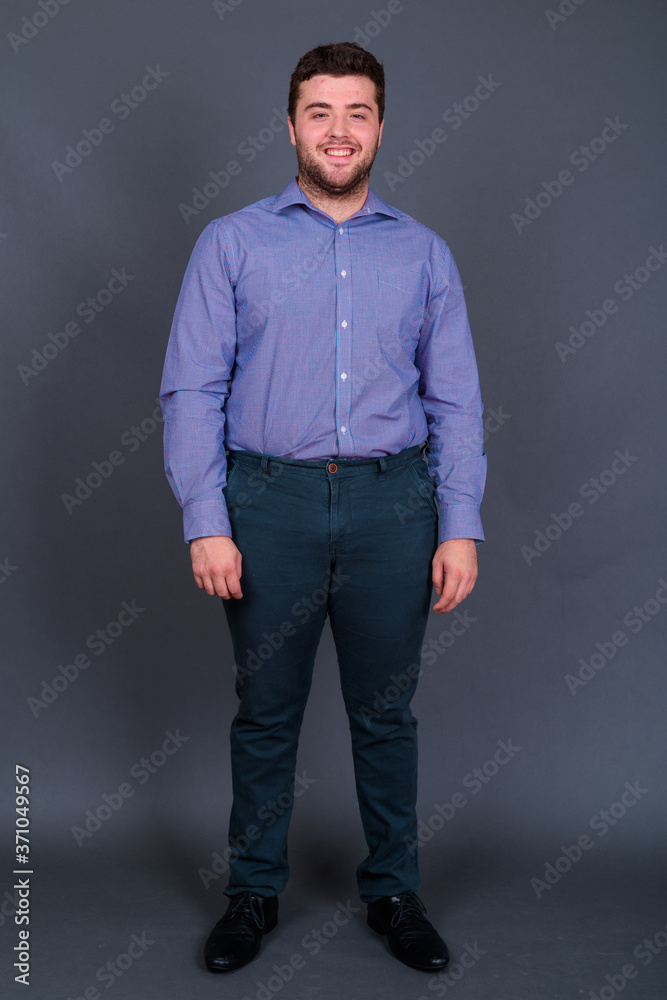 Portrait of happy young handsome overweight bearded businessman Portrait of happy young handsome overweight bearded businessman