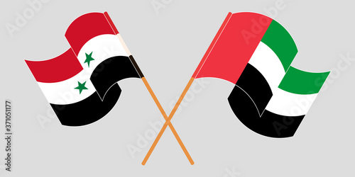Crossed and waving flags of Syria and the United Arab Emirates