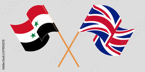 Crossed and waving flags of Syria and the UK