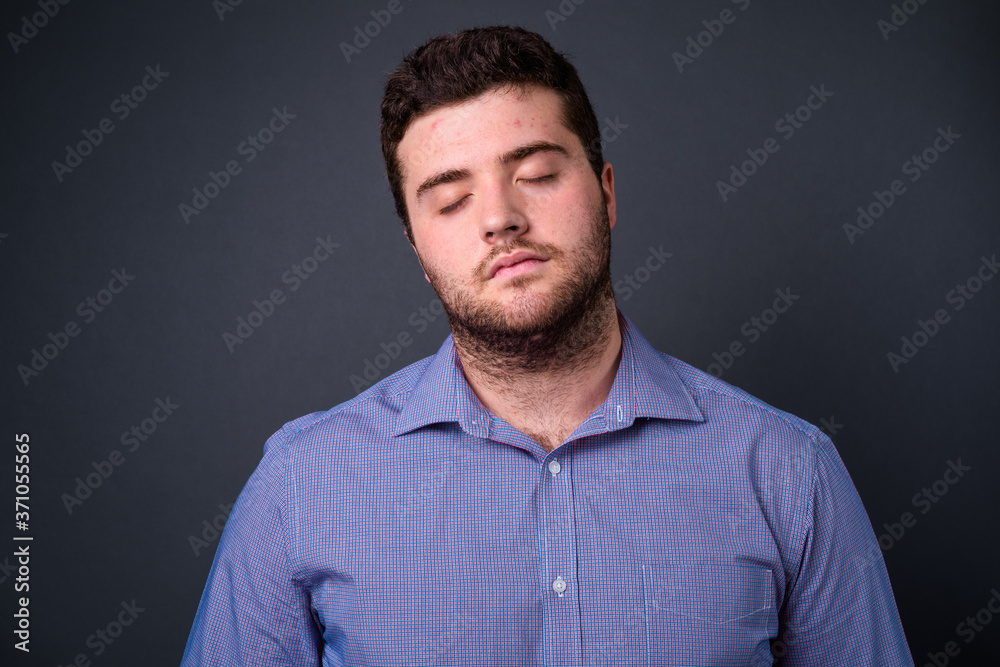 Portrait of young handsome overweight bearded businessman