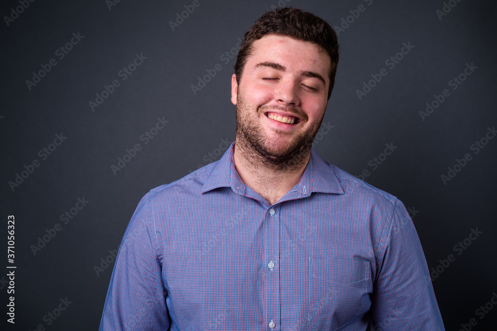 Obraz premium Portrait of happy young handsome overweight bearded businessman