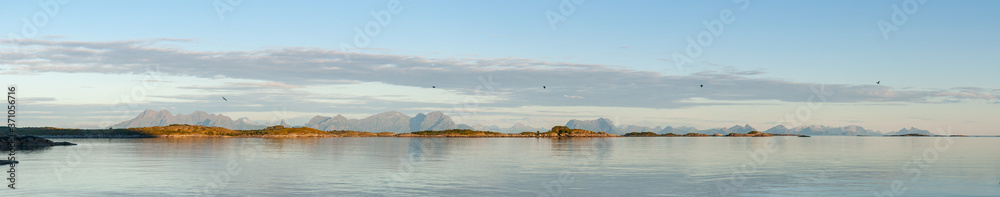 Panorama of mountains on islands above the sea at sunset