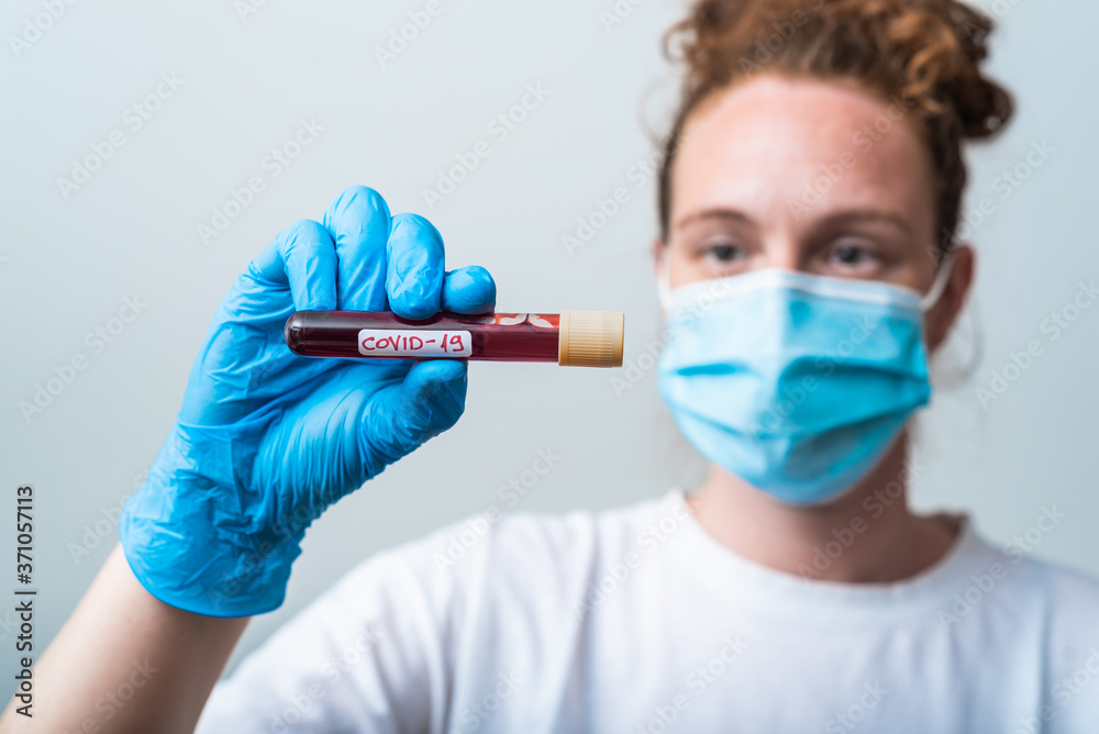A bacteriologist is holding a blood sample to be tested for COVID-19 A bacteriologist is holding a blood sample to be tested for COVID-19