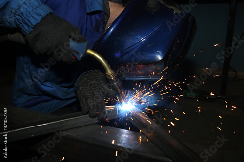 Electric arc welding. The worker welding two iron corners.