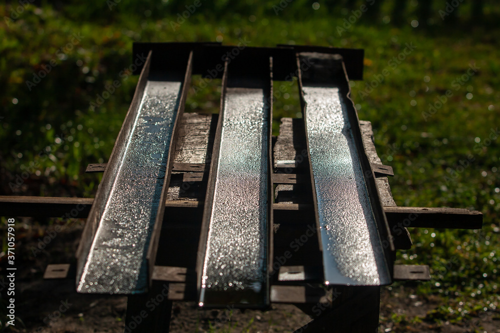 Fototapeta premium three wet rusty channels on a wooden workbench 