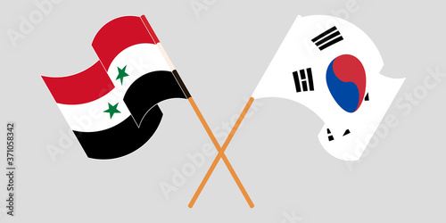 Crossed and waving flags of Syria and South Korea
