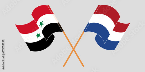 Crossed and waving flags of Syria and the Netherlands