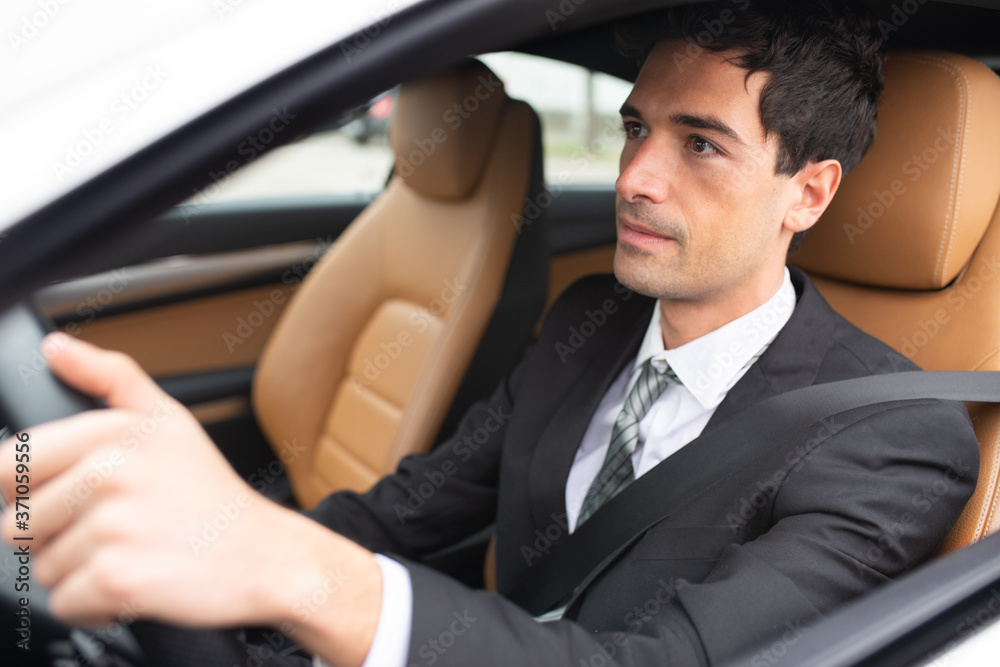 Smiling business man driving his new car