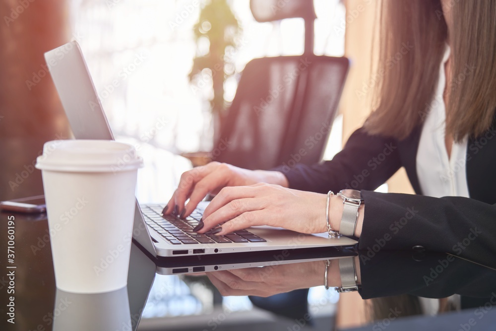 Businesswoman working on laptop in the office. Close up image of female office worker hand typing. Businesswoman working on laptop in the office. Close up image of female office worker hand typing.