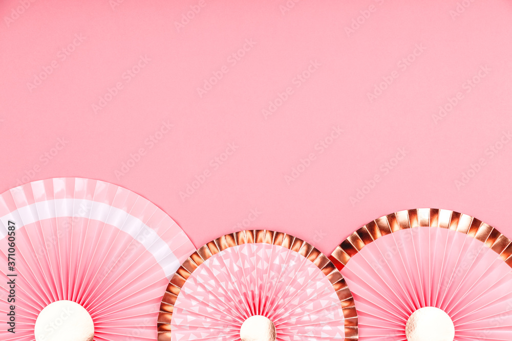 Pink and golden paper fans on pink drop. Party, decorations, celebration backdrop with place for text