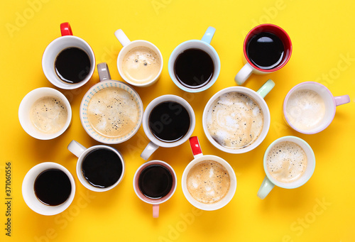 Group of different cups of coffee on yellow background. Top view,flat lay,copy space.