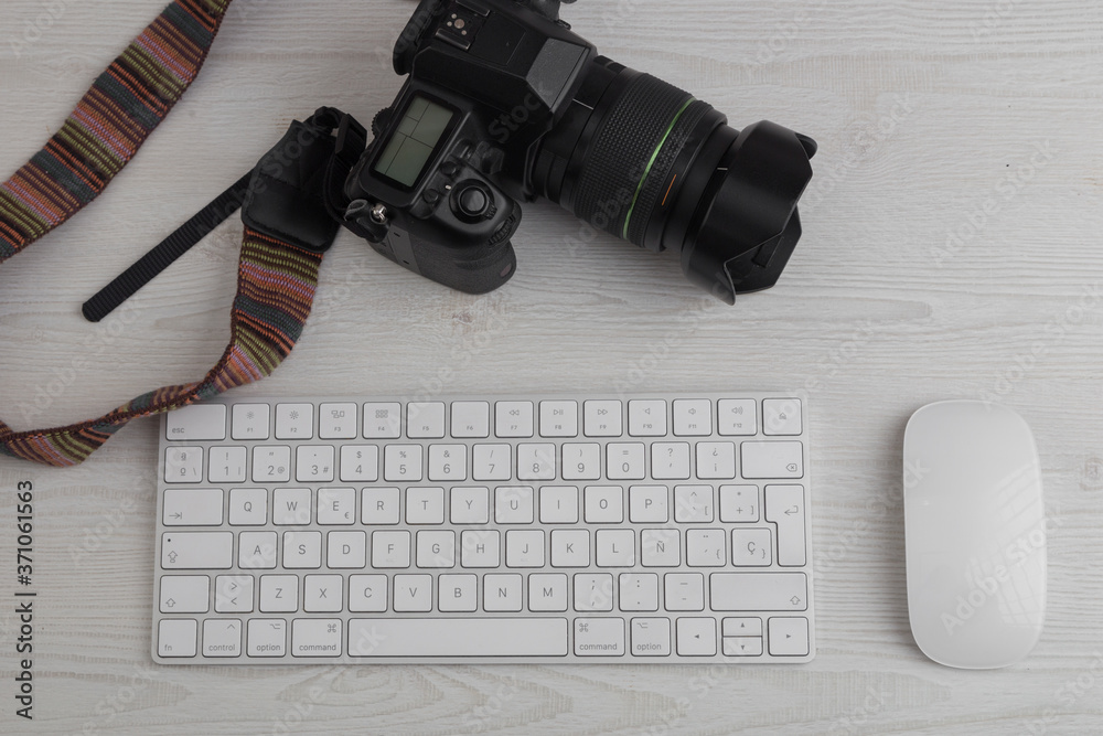 workspace with a keyboard and computer mouse next to a professional photo camera, on a white textured wooden table workspace with a keyboard and computer mouse next to a professional photo camera, on a white textured wooden table