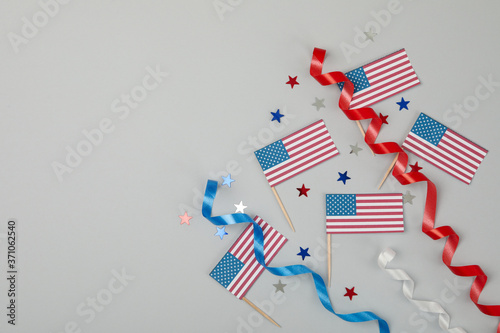 American flags, curly ribbons and stars on gray background