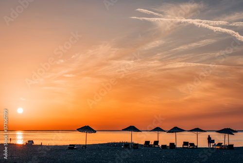 Fototapeta Naklejka Na Ścianę i Meble -  Beach umbrellas at sunrise