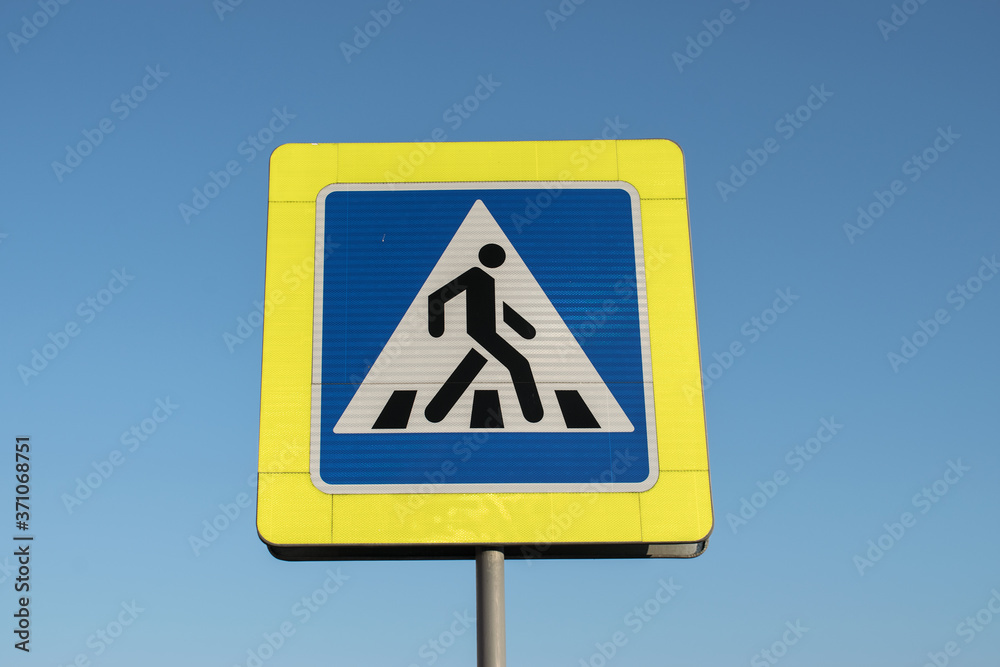 square road sign of a pedestrian crossing with reflective elements on a blue sky background square road sign of a pedestrian crossing with reflective elements on a blue sky background