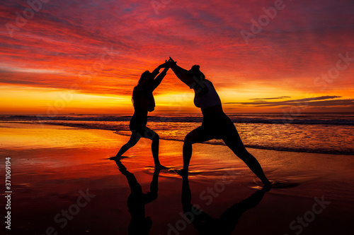 Mother and daughter together during sunrise on the beach