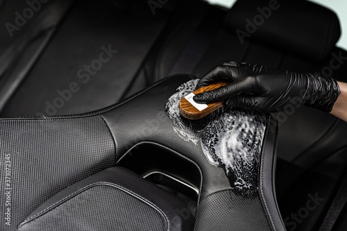 Obraz na płótnie Man in rubber gloves cleaning leather car seat w salonie