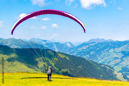 Paraglide launching. Starting procedure of paraglider on high mountain meadow. Recreational and competitive adventure sport